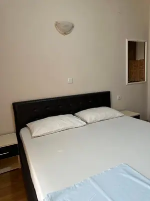 a bed with a black headboard in a room at Apartments Sella in Ulcinj