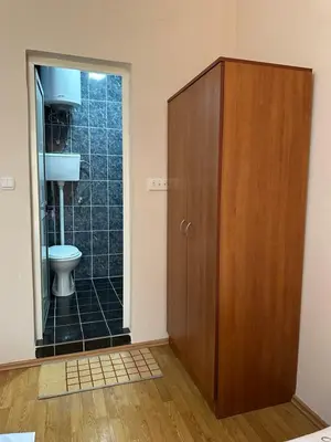 a bathroom with a wooden cabinet and a toilet at Apartments Sella in Ulcinj