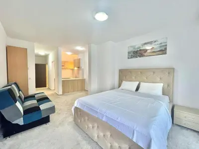 a bedroom with a large bed and a chair at Redondo Apartments Budva in Budva
