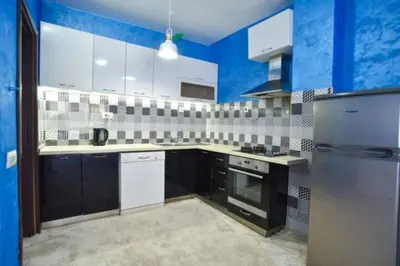 a kitchen with white appliances and blue walls at Redondo Apartments Budva in Budva