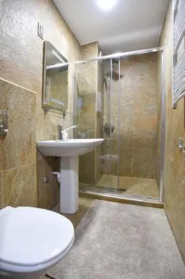 a bathroom with a shower and a toilet and a sink at Redondo Apartments Budva in Budva