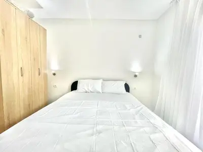 a large white bed in a white room at Redondo Apartments Budva in Budva