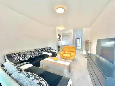a living room with a black couch and a yellow chair at Redondo Apartments Budva in Budva