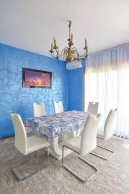 a blue dining room with a table and white chairs at Redondo Apartments Budva in Budva