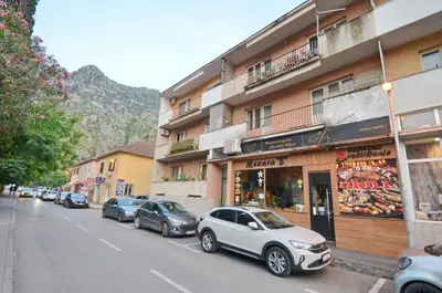a street with cars parked in front of a building at Central Art Oasis Kotor in Kotor
