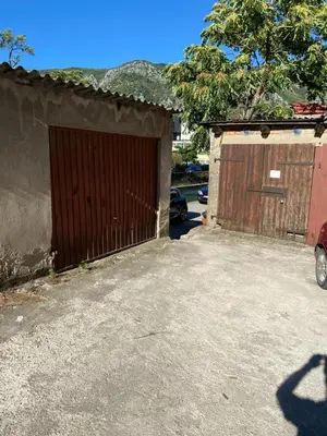 a garage with a gate and a car parked next to it at Central Art Oasis Kotor in Kotor