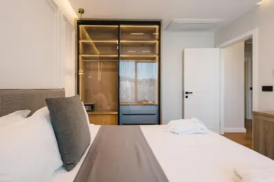 a bedroom with a large white bed and a closet at Hotel Teuta in Ulcinj