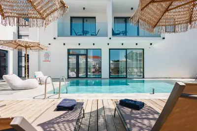a swimming pool with umbrellas in a building at Hotel Teuta in Ulcinj