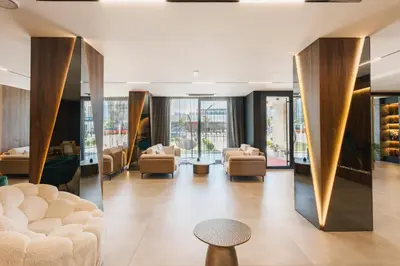 a lobby with couches and a table and windows at Hotel Teuta in Ulcinj