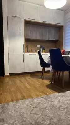 a kitchen with a table and two blue chairs at Apartman Jakov in Becici