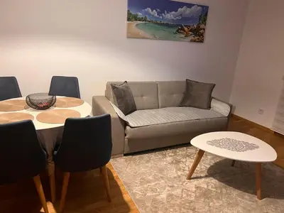 a living room with a couch and a table and chairs at Apartman Jakov in Becici