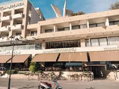 a building with tables and chairs in front of it at Miramar in Ulcinj
