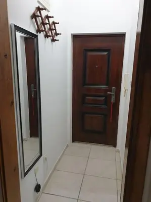 a hallway with a wooden door and a mirror at Warm & Welcoming Vele Residence in Bar