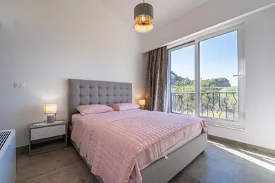 a bedroom with a bed and a large window at Ventus Rosa Villa in Budva