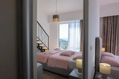 a bedroom with a bed and a large window at Ventus Rosa Villa in Budva