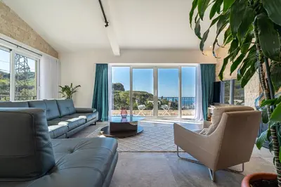 a living room with a couch and a large window at Ventus Rosa Villa in Budva