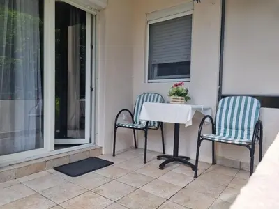 two chairs and a table on a porch at Apartment Ninas in Dobrota