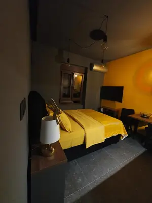 a bedroom with a yellow bed with a lamp and a table at Studio apartman Luka in Cetinje
