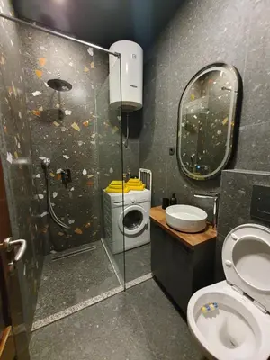 a bathroom with a shower with a toilet and a mirror at Studio apartman Luka in Cetinje