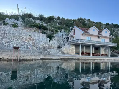a house sitting next to a body of water at Lake Skadar Paradise in Podgorica