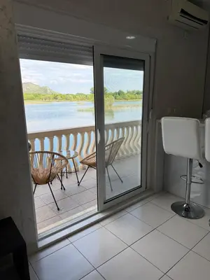 a room with a balcony with a view of the water at Lake Skadar Paradise in Podgorica