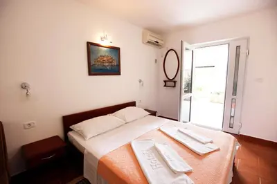 a bedroom with a bed with two towels on it at Apartments Baron in Sveti Stefan