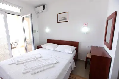 a bedroom with a bed with two towels on it at Apartments Baron in Sveti Stefan