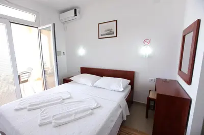 a bedroom with a bed with two towels on it at Apartments Baron in Sveti Stefan