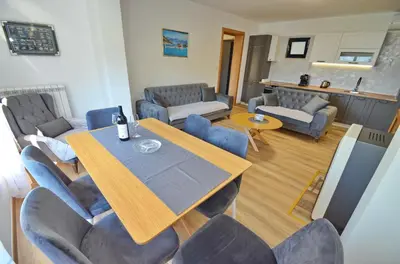 a living room with a wooden table and chairs at Radgost Kotor Apartments in Kotor