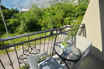a table and chairs on a balcony with a view at Radgost Kotor Apartments in Kotor