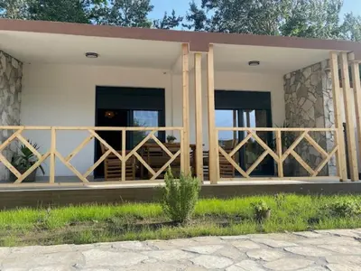 a house with a wooden fence in front of it at Sabina Bungalow - Long Beach in Ulcinj