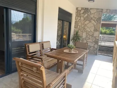 a wooden table and chairs on a patio at Sabina Bungalow - Long Beach in Ulcinj