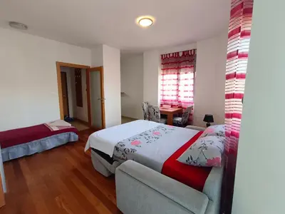 a bedroom with a bed and a chair and a window at Center Studio in Petrovac na Moru