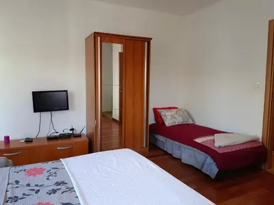 a bedroom with two beds and a tv in it at Center Studio in Petrovac na Moru