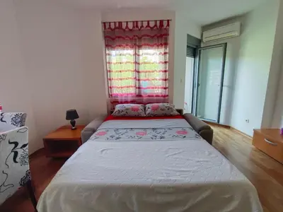a bedroom with a large bed with a window at Center Studio in Petrovac na Moru