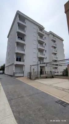 a large white building with balconies on a street at Apartments LORA Susanj #39 in Bar