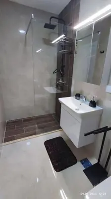 a white bathroom with a shower and a sink at Apartments LORA Susanj #39 in Bar