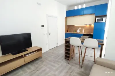 a kitchen with a flat screen tv and two stools at Apartments LORA Susanj #39 in Bar