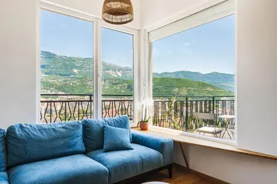 a blue couch in a room with a large window at 2-floor penthouse with stunning views in Budva
