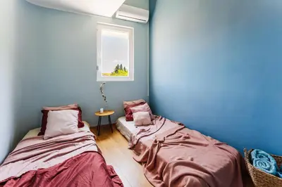 two beds in a room with blue walls and a window at 2-floor penthouse with stunning views in Budva