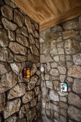 a stone wall with a shower in a bathroom at Carevic Resort & Villas in Budva
