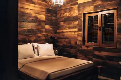 a bedroom with wooden walls and a bed with a window at Carevic Resort & Villas in Budva