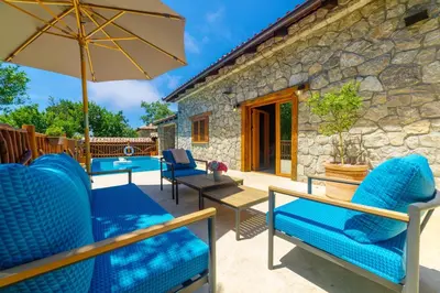 a patio with blue chairs and an umbrella at Carevic Resort & Villas in Budva