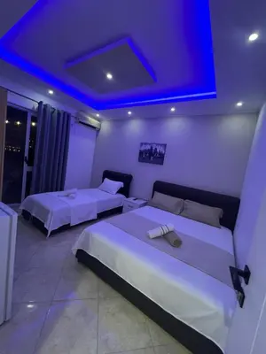 a bedroom with two beds and a blue lighting at Keon in Ulcinj