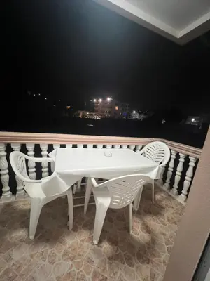 a white table and chairs on a balcony at night at Keon in Ulcinj