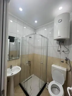 a bathroom with a shower and a toilet and a sink at Keon in Ulcinj