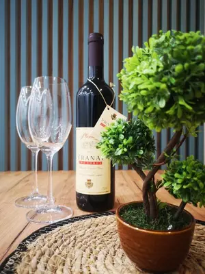 a bottle of wine and two wine glasses on a table at Sunset Apartment in Kotor