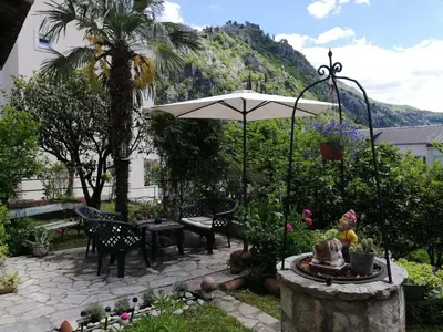 a patio with an umbrella and a table and chairs at Apartments Sandra in Kotor