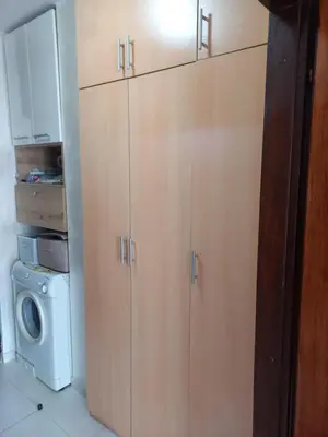 a kitchen with wooden cabinets and a washing machine at STELLA di mare in Sutomore