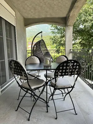 a table and four chairs on a porch at Sunrise Apartment in Kotor